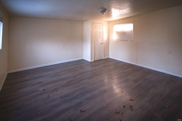 spare room with ornamental molding and dark wood-type flooring