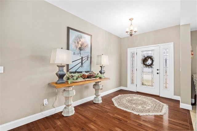 entrance foyer featuring dark wood-type flooring and an inviting chandelier