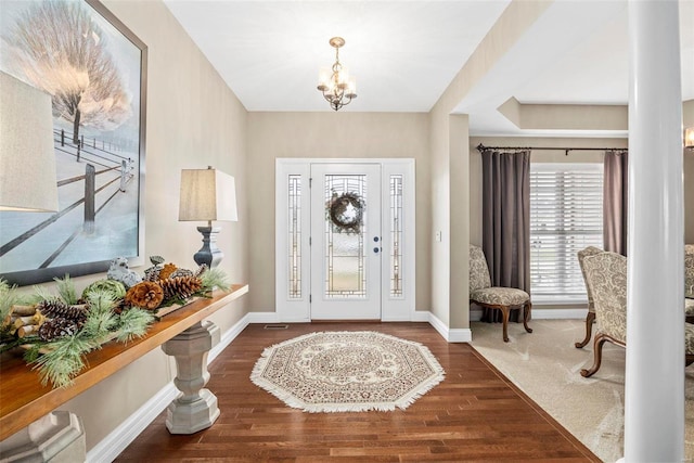 foyer featuring dark wood-type flooring and a chandelier