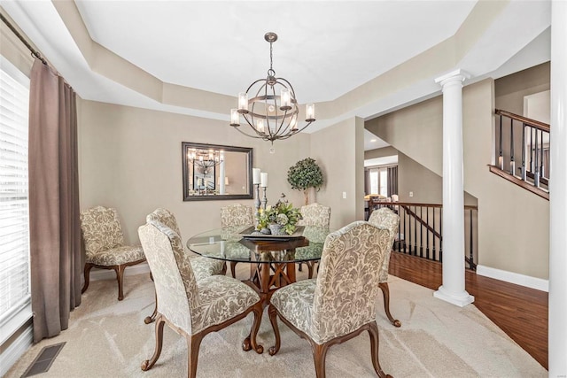 dining area with light hardwood / wood-style flooring, decorative columns, and a chandelier