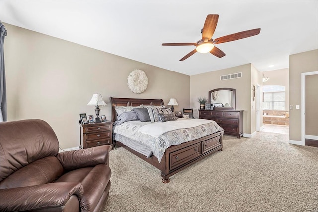 carpeted bedroom with ensuite bathroom and ceiling fan