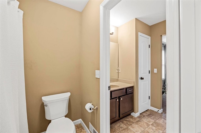 bathroom with visible vents, baseboards, toilet, and vanity