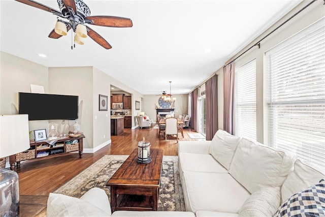 living area with ceiling fan, baseboards, and wood finished floors