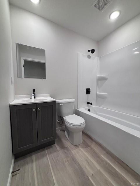 full bathroom with hardwood / wood-style flooring,  shower combination, toilet, and vanity