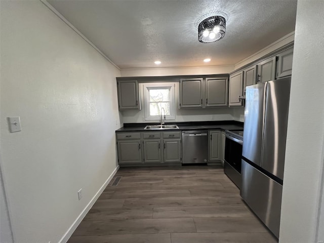 kitchen featuring sink, gray cabinetry, stainless steel appliances, dark hardwood / wood-style floors, and a textured ceiling