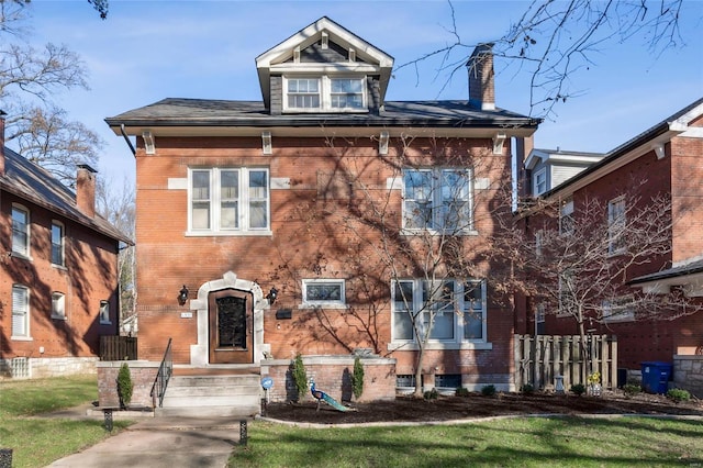 view of front of property with brick siding, a chimney, and fence