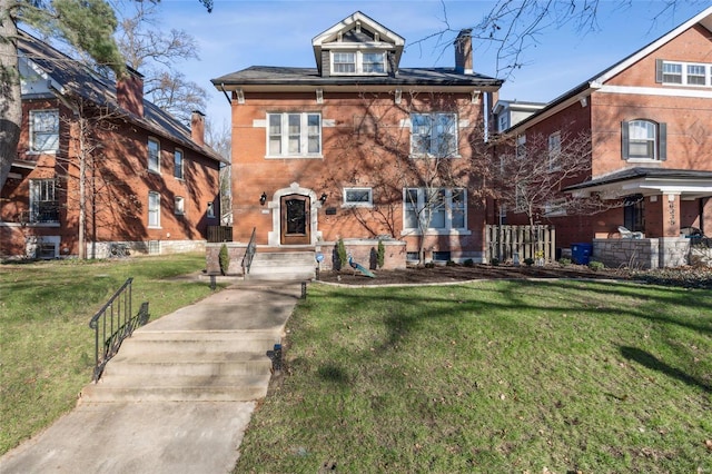 view of front facade with cooling unit, brick siding, a chimney, and a front yard