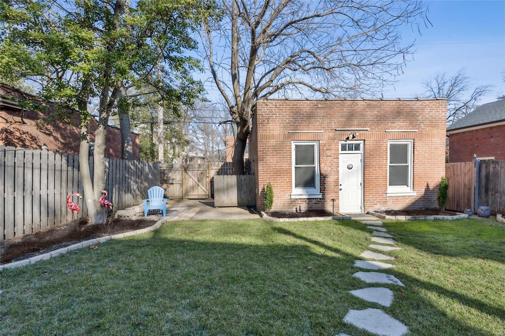 exterior space with a fenced backyard and a gate