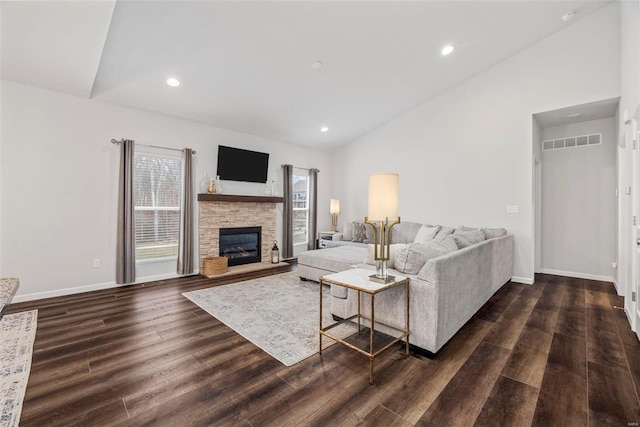 living room featuring vaulted ceiling, a fireplace, and dark hardwood / wood-style flooring