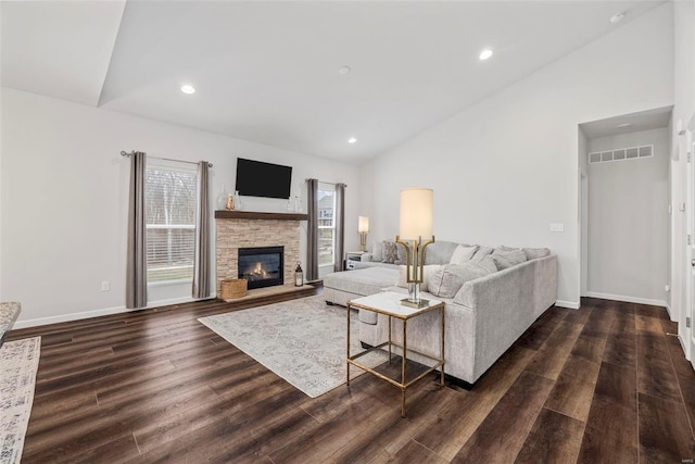 living room featuring lofted ceiling, dark hardwood / wood-style floors, and a fireplace