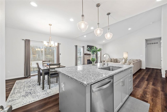 kitchen with sink, decorative light fixtures, dishwasher, and a center island with sink