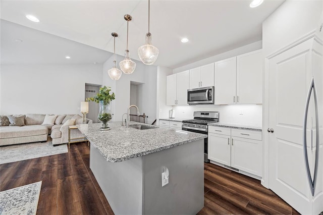 kitchen with appliances with stainless steel finishes, sink, a center island with sink, and white cabinets