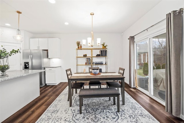 dining space with an inviting chandelier and dark hardwood / wood-style floors