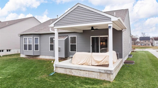 back of house featuring a yard and ceiling fan