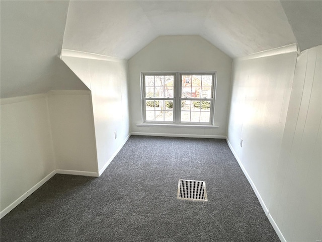 bonus room featuring dark colored carpet and vaulted ceiling