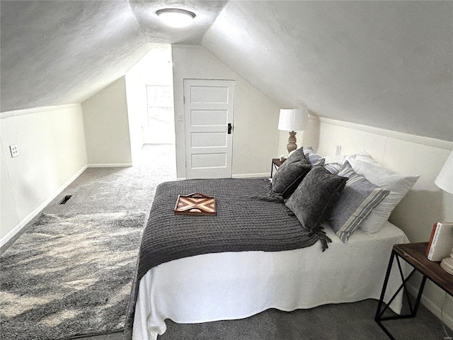 carpeted bedroom with vaulted ceiling and a textured ceiling