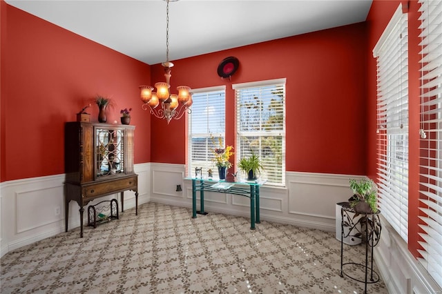 dining area with an inviting chandelier and wainscoting