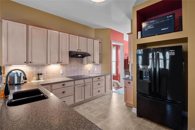 kitchen with decorative backsplash, under cabinet range hood, vaulted ceiling, black appliances, and a sink