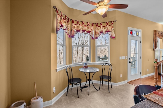 dining area with ceiling fan and baseboards