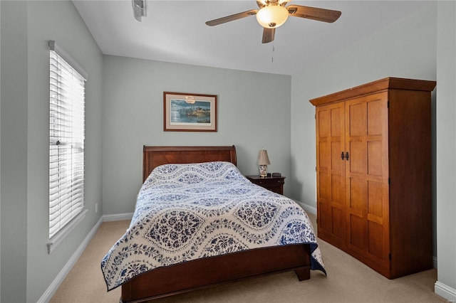 bedroom with light carpet, a ceiling fan, and baseboards