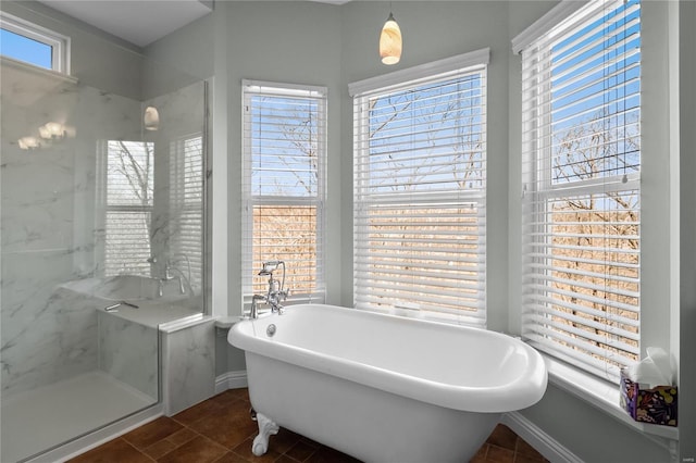 bathroom with a freestanding tub, tile patterned flooring, a marble finish shower, and baseboards