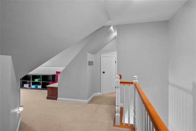 additional living space with carpet, visible vents, vaulted ceiling, and baseboards