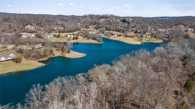 drone / aerial view featuring a water view and a wooded view