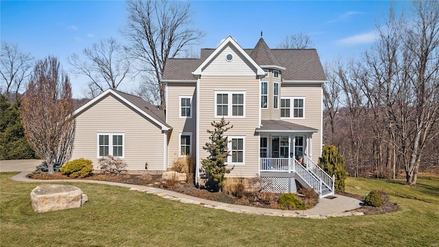 view of front of house with covered porch and a front lawn