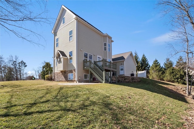 rear view of property with a deck, a lawn, stairway, and a patio