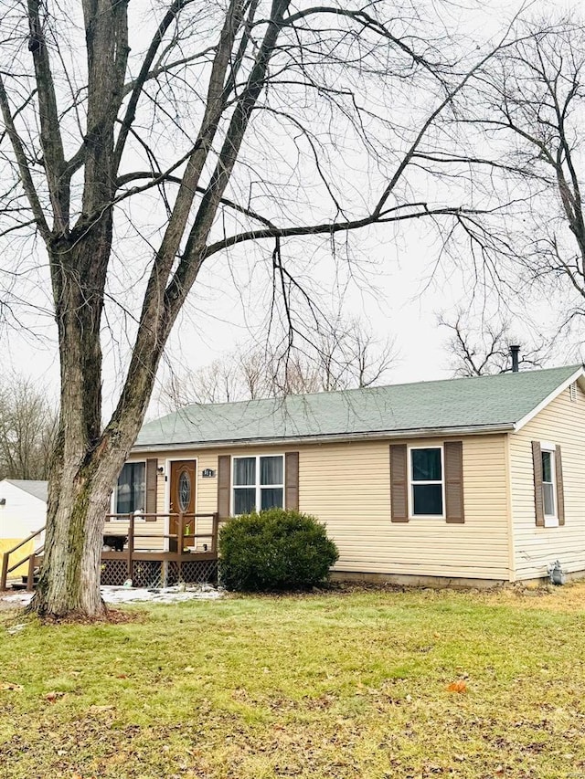 view of front of house with a wooden deck and a front lawn