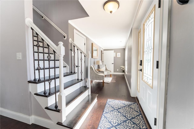 entryway featuring ornamental molding, dark wood-style flooring, stairway, and baseboards