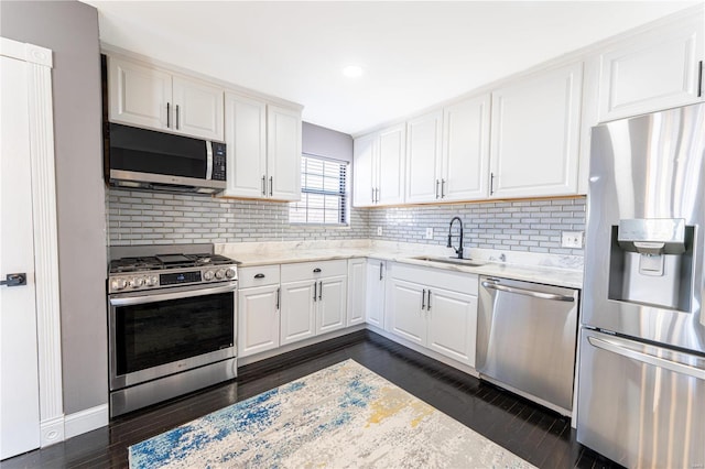 kitchen featuring dark wood-style floors, white cabinetry, stainless steel appliances, and a sink