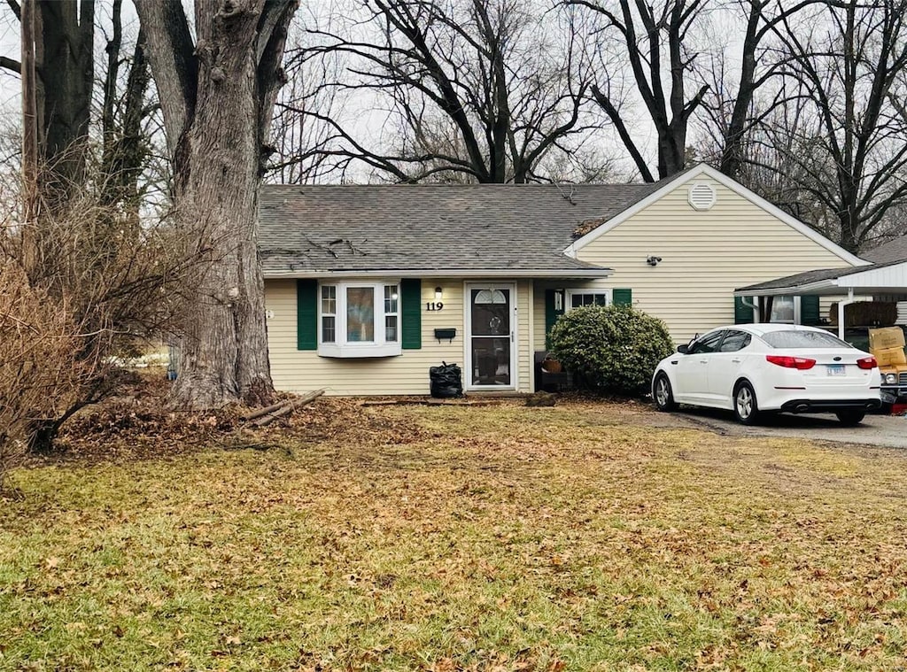 ranch-style home with a front lawn and a shingled roof