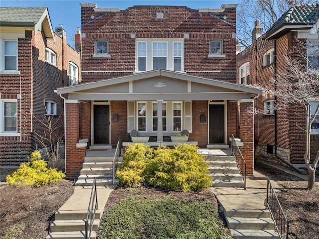 view of front of home featuring covered porch and brick siding