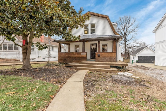 view of front facade featuring a porch, a garage, and an outdoor structure