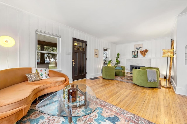 living room featuring hardwood / wood-style flooring and a brick fireplace