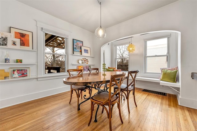 dining area with light hardwood / wood-style floors and a healthy amount of sunlight