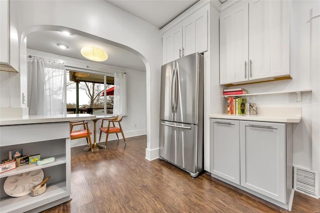 kitchen with white cabinetry, dark hardwood / wood-style floors, and stainless steel fridge