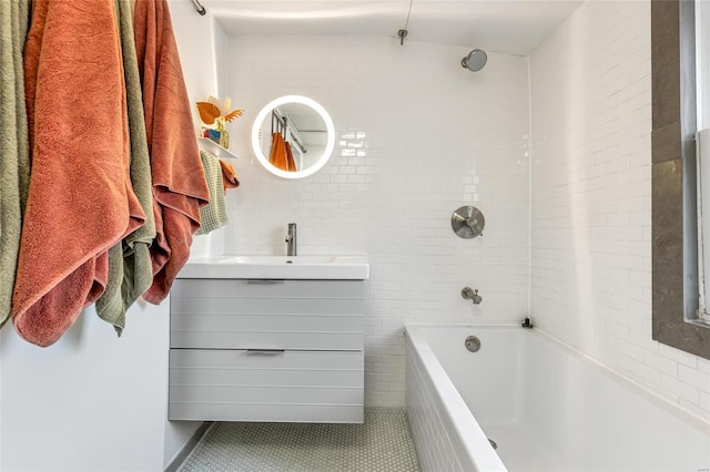 bathroom featuring vanity, tile patterned flooring, tiled shower / bath combo, and tile walls