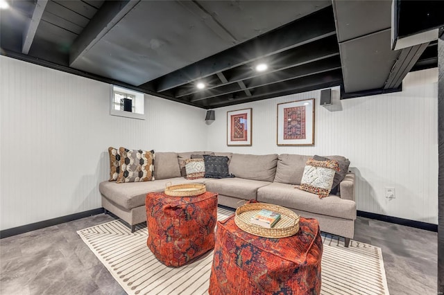 living room with beam ceiling and concrete floors