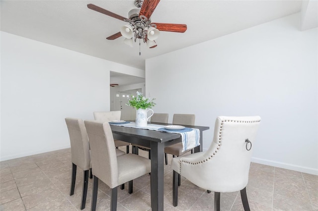 dining space with ceiling fan and baseboards