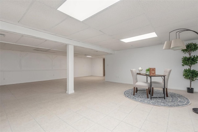 finished below grade area with a paneled ceiling and tile patterned floors