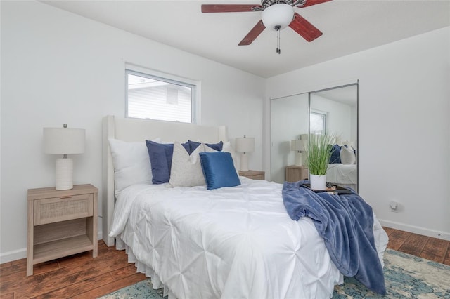 bedroom with a ceiling fan, a closet, baseboards, and dark wood-type flooring