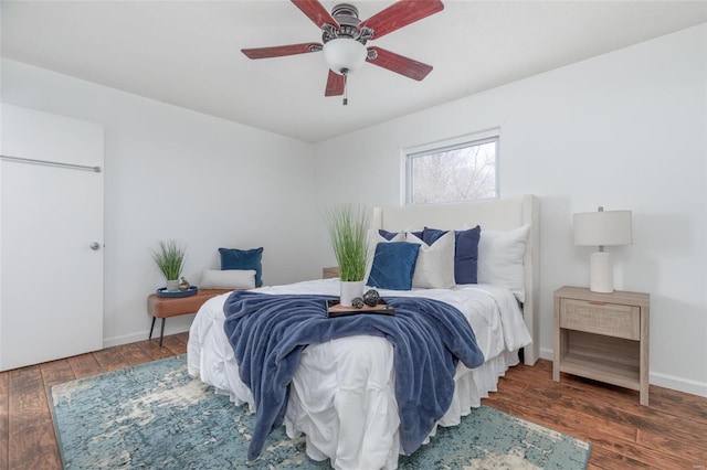 bedroom with dark wood-type flooring, ceiling fan, and baseboards