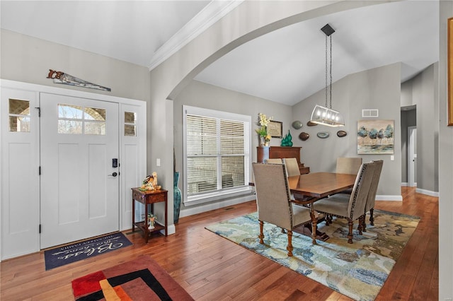 dining space featuring lofted ceiling, hardwood / wood-style floors, and a chandelier