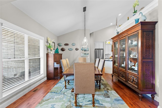 dining space featuring dark wood-type flooring and lofted ceiling