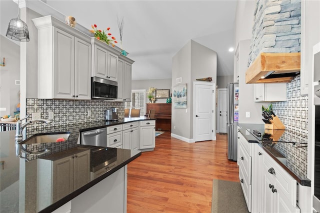 kitchen with sink, tasteful backsplash, light hardwood / wood-style flooring, appliances with stainless steel finishes, and white cabinets