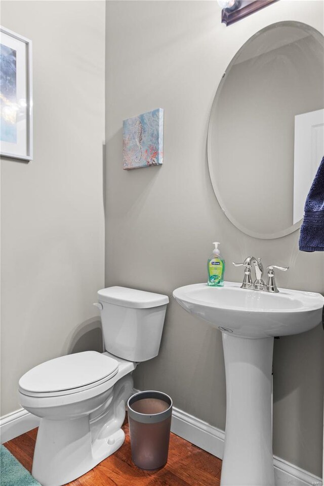 bathroom featuring wood-type flooring, sink, and toilet