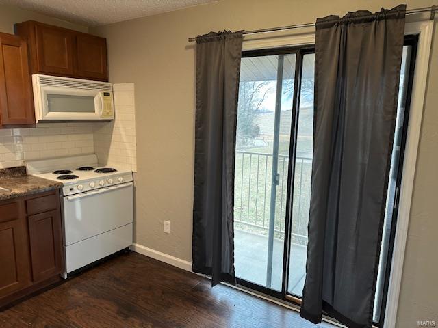 kitchen with white appliances, decorative backsplash, dark countertops, brown cabinets, and a textured ceiling