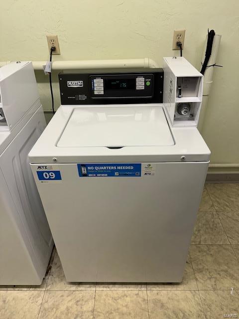 shared laundry area with washer and clothes dryer and light tile patterned flooring